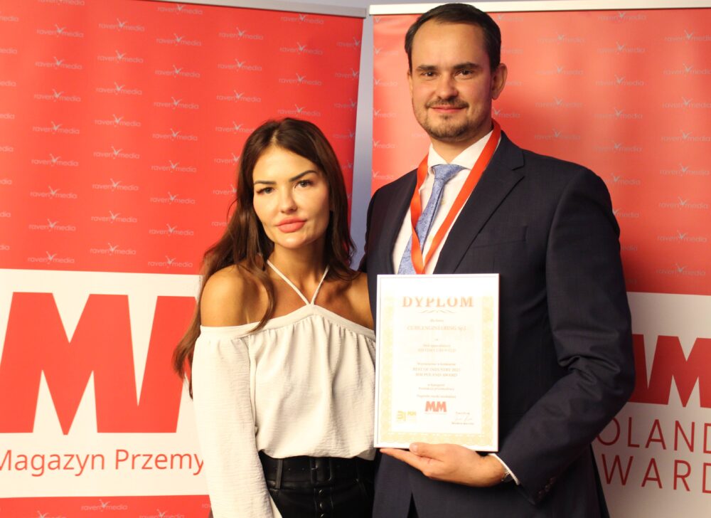 Para z dyplomem na czerwonym tle.